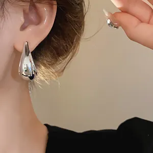 Elegant silver metal waterdrop stud earrings shown on model for a sleek look