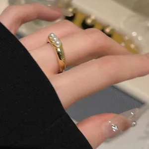 Primo piano di un anello placcato oro con tre eleganti pietre occhio di gatto al dito