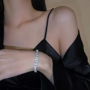 Elegant detail view of a sparkling zircon flower bracelet on an Asian model's wrist