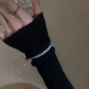 Close-up detail of a sparkling zircon adjustable bracelet on a black ribbed sleeve