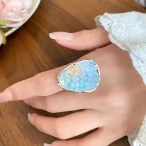 French vintage beaded ring with natural sea shell and light blue stones on model hand