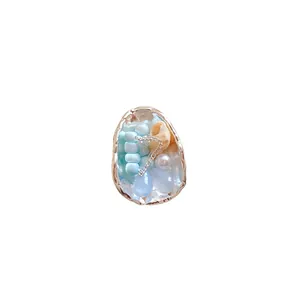 French vintage shell and conch beaded ring featuring blue stones in a gold frame