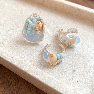 Close-up of vintage French style shell and stone beaded rings with elegant pearl details