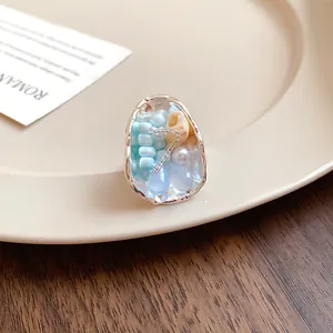 Macro view of French vintage ring featuring beads and conch shell inside an oval frame