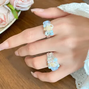 Detailed close-up showing French vintage seashell and blue stone beaded rings on hand