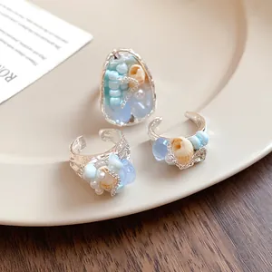 Detailed view of French vintage shell and bead rings placed on a cream ceramic plate