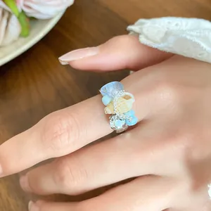 Macro detail of a French retro ring featuring shells, conch, and light blue beads