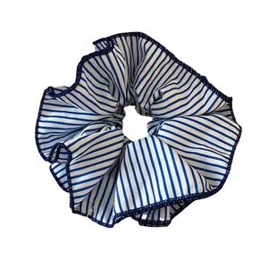 Large pleated hair scrunchie featuring blue and white stripes and navy stitched edges.