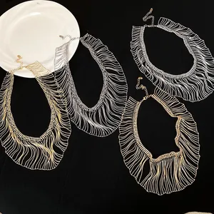 Top view of four elegant gold and silver metal fringe necklaces on a black background