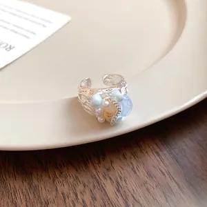 Close-up view of French vintage silver ring decorated with shell, conch, and faux pearls