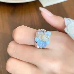 Detailed close-up showing a vintage French shell and blue stone beaded ring on a hand.