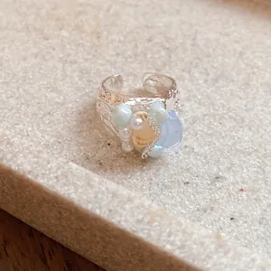 Macro detail of French vintage shell and light blue stone beaded silver open ring