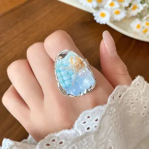 Detailed close-up of a vintage French shell and bead ring featuring pearls on hand