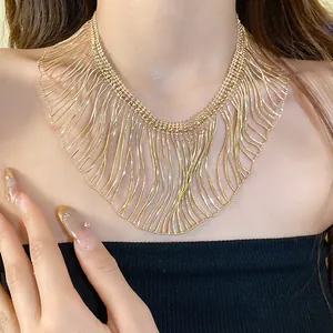 Detailed macro close-up of a golden metal fringe necklace with delicate dangling snake chains.