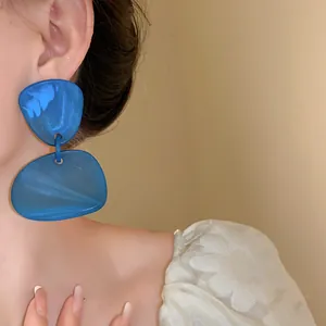 Detail shot of a model wearing retro blue geometric irregular dyed drop earrings