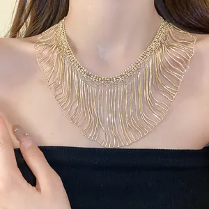Detailed view of luxury gold multi-layered snake chain tassel necklace on model's neck