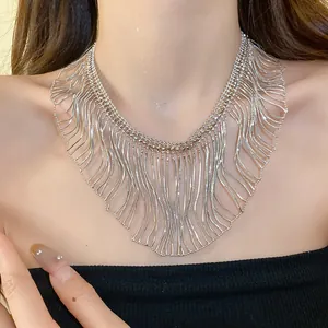 Close-up detail of a high-end silver wavy snake chain fringe statement necklace on a model