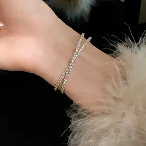 Elegant double-layer criss-cross zircon bracelet with gold finish on model's wrist