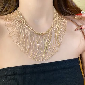 Close-up view of a golden metallic fringe necklace on model for detail.