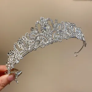 Close-up detail of an elegant silver bridal tiara with rhinestones and teardrop stone.