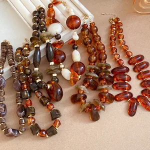 Macro view of retro Maillard style resin bead necklaces with irregular amber textures.