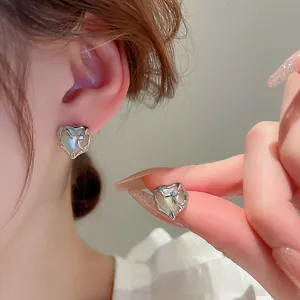 Detail view of heart-shaped cat-eye stone earrings with vintage silver molten metal frame