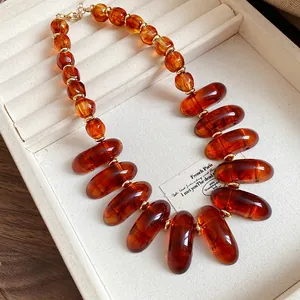 Close-up of retro amber-colored resin bead necklace with vintage Maillard aesthetic