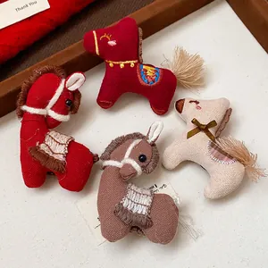 Gros plan de quatre broches cheval en tricot avec broderies et détails de glands