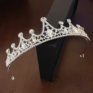 Close-up of elegant silver tiara with intricate rhinestone flower and waterdrop patterns.