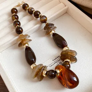 Macro detail of vintage Maillard style necklace with marbled resin beads and gold accents