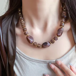 Detail view of a Maillard retro marbled irregular bead necklace worn on a woman's neck