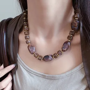 Macro view of vintage Maillard style marbled resin bead necklace on a model neck