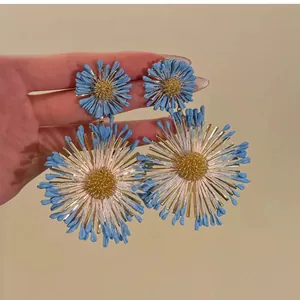 Oversized blue floral statement earrings with golden textured centers for women.