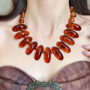 Close-up of a vintage Maillard style necklace with amber-colored halo-dyed beads