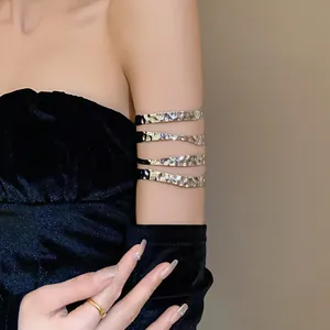 Dettaglio di un bracciale da braccio in metallo martellato multistrato color argento.