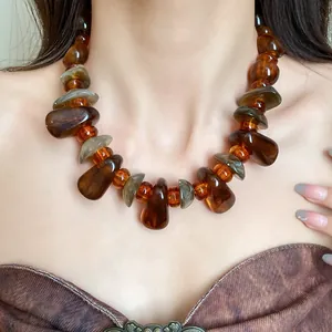 Close-up detail showing the texture of a vintage amber marbled irregular bead necklace