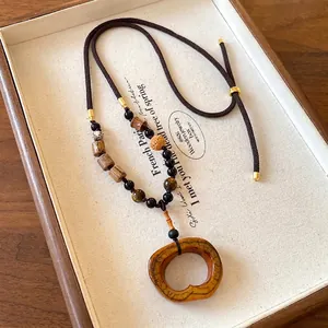 Vintage ethnic style bohemian necklace with amber-colored oval ceramic pendant