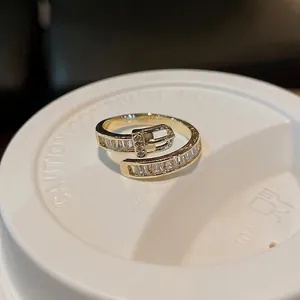 Elegant gold-plated belt buckle ring featuring sparkling baguette zircons and adjustable band