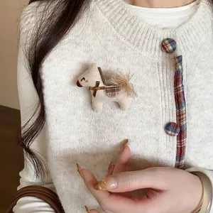 Gros plan détaillé d'une jolie broche cheval en tricot avec nœud sur un gilet blanc