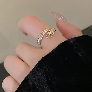 Gold plated belt buckle ring with sparkling zircons worn on a fashion model's finger