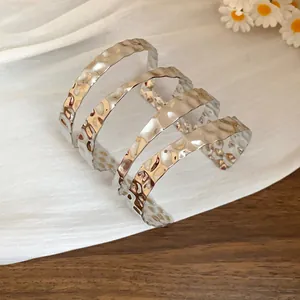 Primo piano di un bracciale a fascia multistrato martellato in argento con texture.