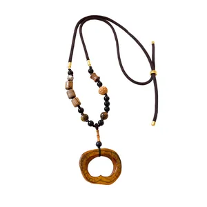 Ethnic style bohemian necklace with oval ceramic pendant and beaded brown cord