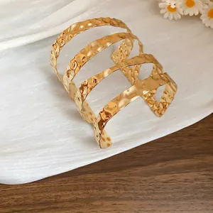 Dettaglio ravvicinato di un bracciale a fascia multistrato in metallo martellato
