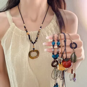 Close-up of ethnic style ceramic necklaces with bohemian beads and wood details