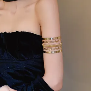 Ripresa dettagliata di un bracciale da braccio multistrato in metallo dorato lucido.