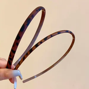 Close-up of retro leopard print matte headbands showing texture and thin design
