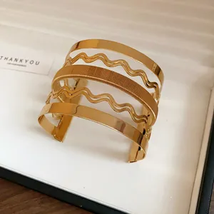 Dettaglio di un raffinato bracciale rigido dorato multistrato con strati ondulati