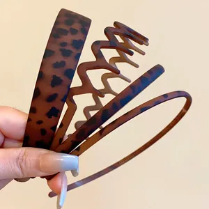 Close-up detail of four assorted matte leopard print headbands with different widths