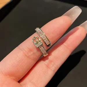 Close-up detail of a gold-plated belt buckle ring featuring sparkling rectangular zircons