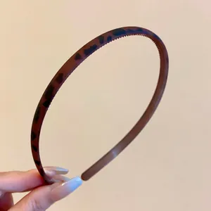 Close-up of a slim leopard print headband with matte finish and non-slip inner teeth